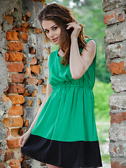 Loretta strips her green sexy flowing dress and flaunts her lean, nubile body and delectable pussy by the brick wall ruins.