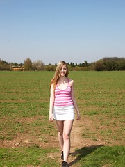 A daring and quite nude teenager masturbates on some grass
